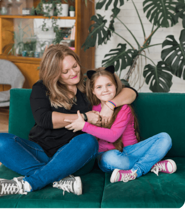 mom-with-daughter-hugging-on-a-coach